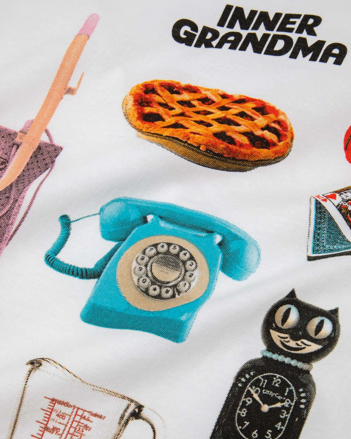 White Retro Inner Grandma graphic tee including a pie, blue phone, cat clock, and glass measuring cup on a white background