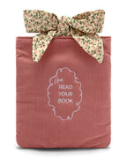 Pink corduroy bag sleeve with floral ribbon and 'Girl Read Your Book' embroidery.