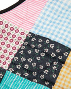 Patchwork of colorful fabric squares with floral, checkered, and striped patterns.
