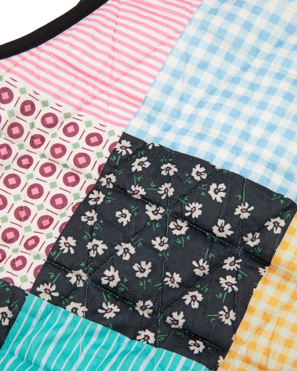 Patchwork of colorful fabric squares with floral, checkered, and striped patterns.
