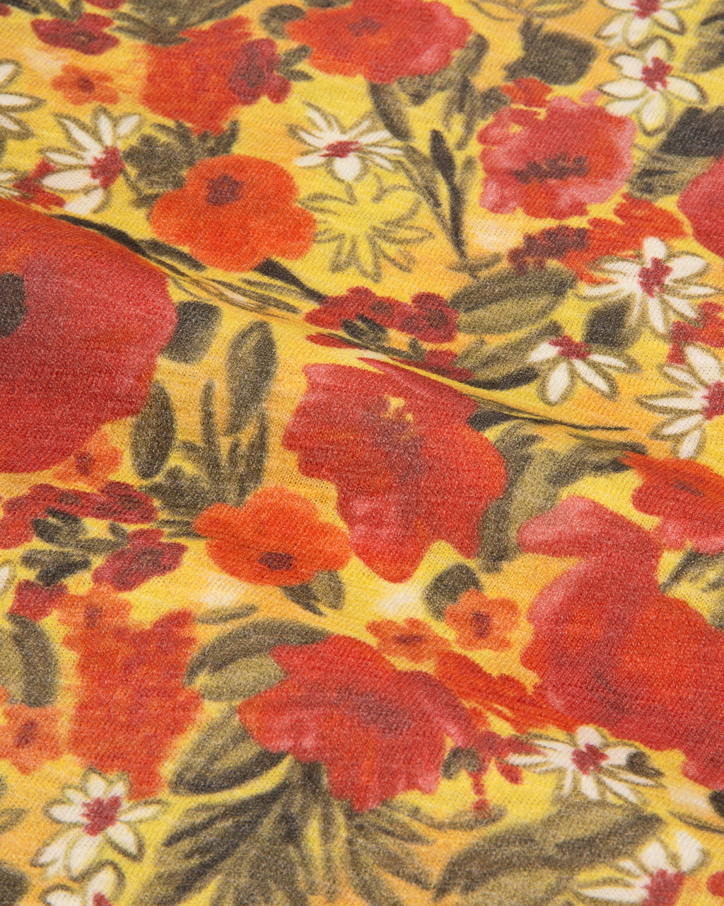 A close-up of a vintage floral fabric print featuring large red poppies, white daisies, and green leaves on a warm yellow background.