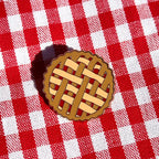 Pie crust pin design on a red and white checkered fabric background