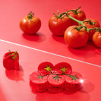 Red tomatoes on a red surface with a hair claw clip shaped like a tomato.
