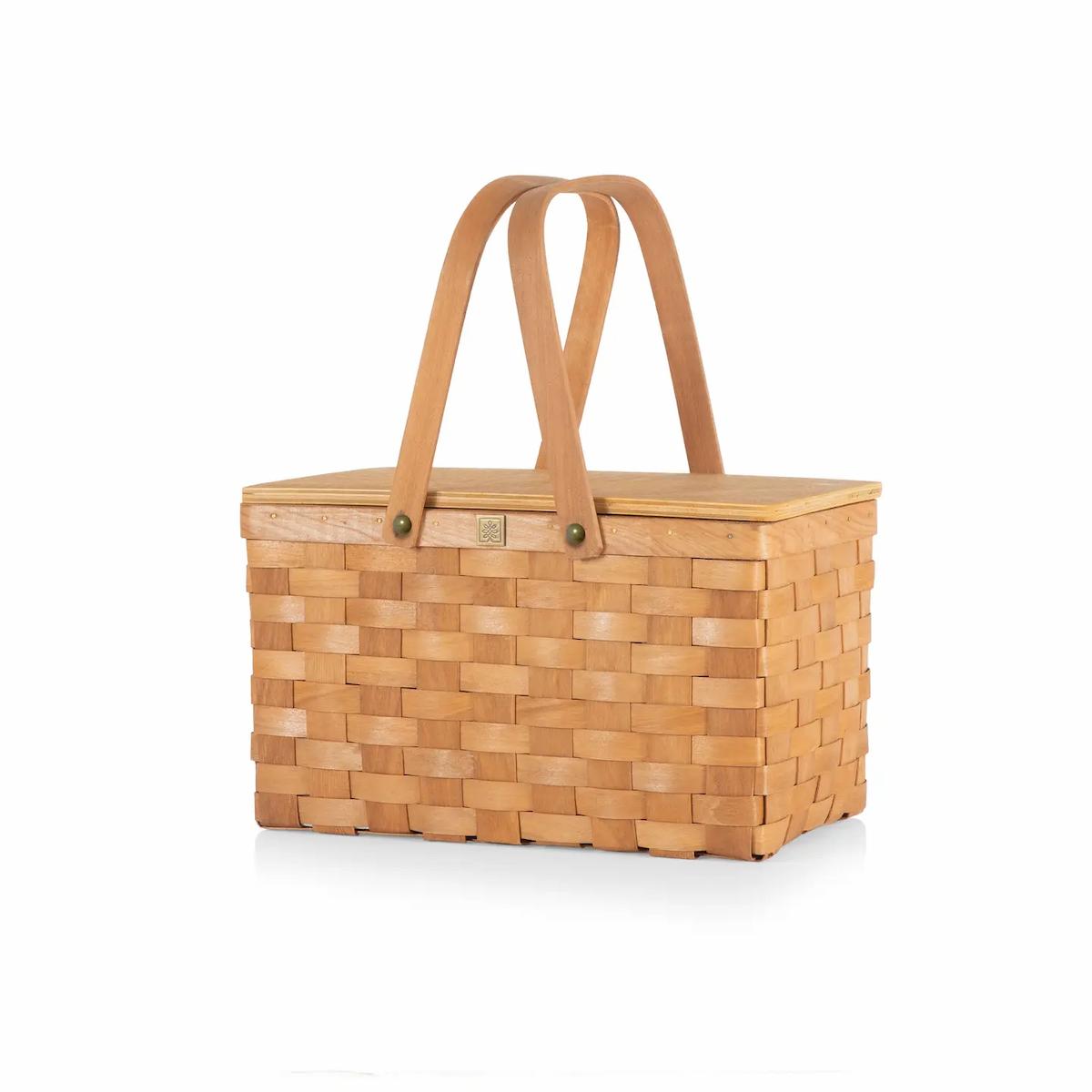 Woven picnic basket with a lid on a white background
