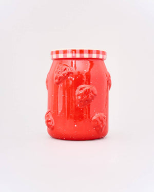 Red jar with checkered lid on a white background. 