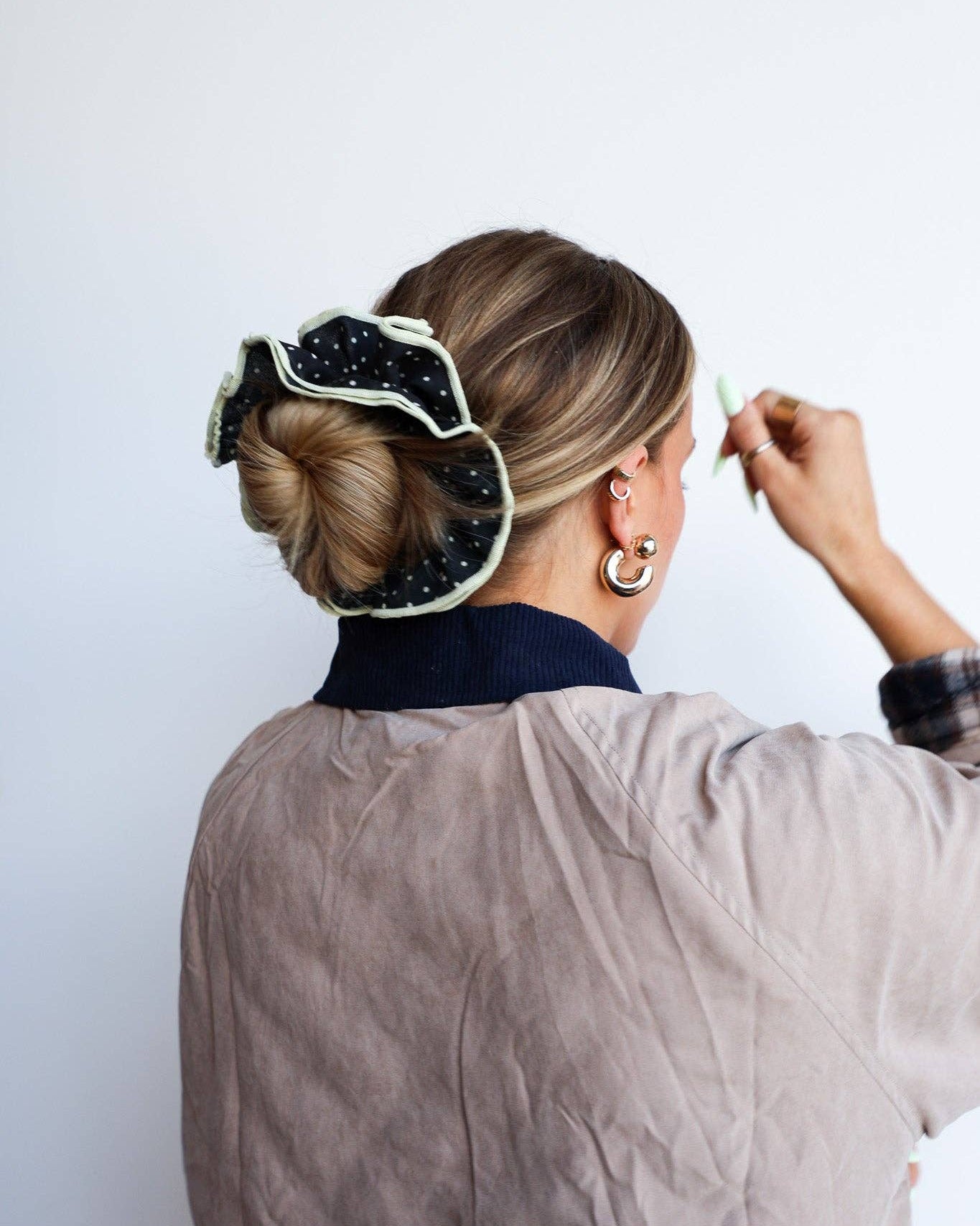 Person wearing a black and white scrunchie against a white background