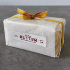 Beeswax candle wrapped in paper with a yellow ribbon on a gray surface