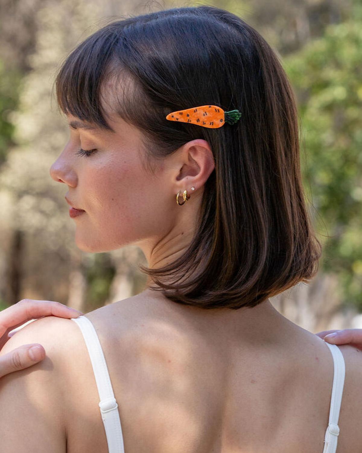 Woman with a carrot-shaped hair clip outdoors