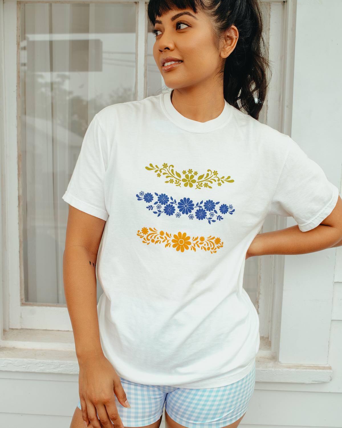 Woman wearing a white t-shirt with floral designs outdoors