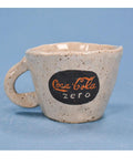 Speckled ceramic mug with Coca-Cola Zero logo on a blue background