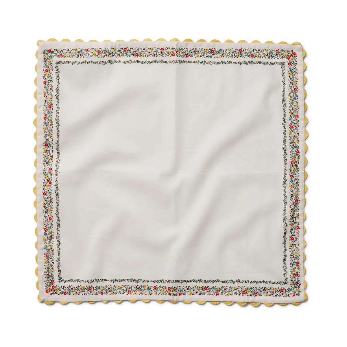 White napkin with a decorative floral border on a white background