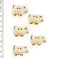 Five white sheep-shaped buttons with black details on a white background, accompanied by a ruler for scale.
