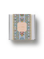 Decorative box with floral design and pink label on a white background