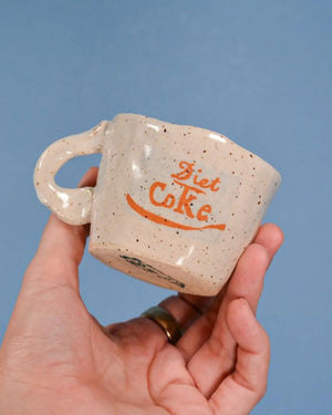 speckled coffee cup with blue background