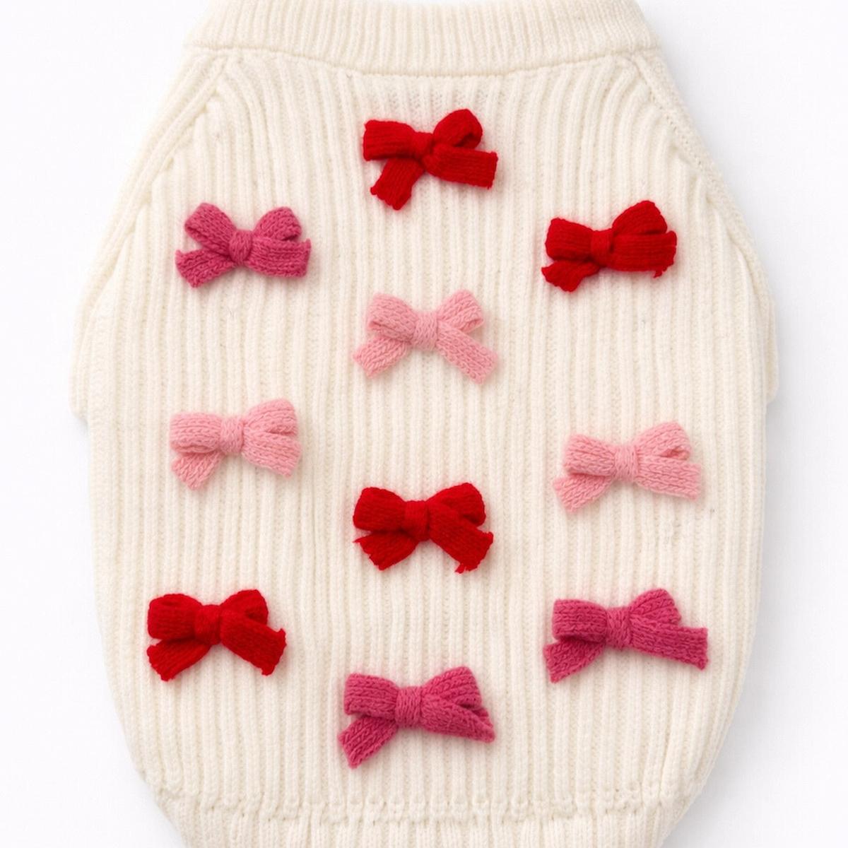 White textured surface with red and pink bows arranged in a pattern