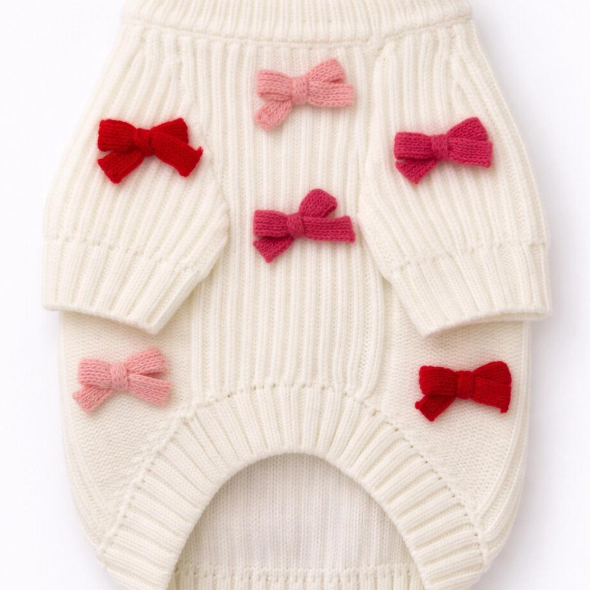 White knitted romper with red and pink bows on a white background