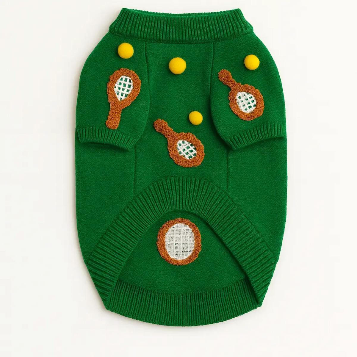 Green dog sweater with tennis ball and racket designs on a white background