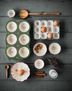 Collection of ceramic dishes and kitchen items on a dark wooden surface