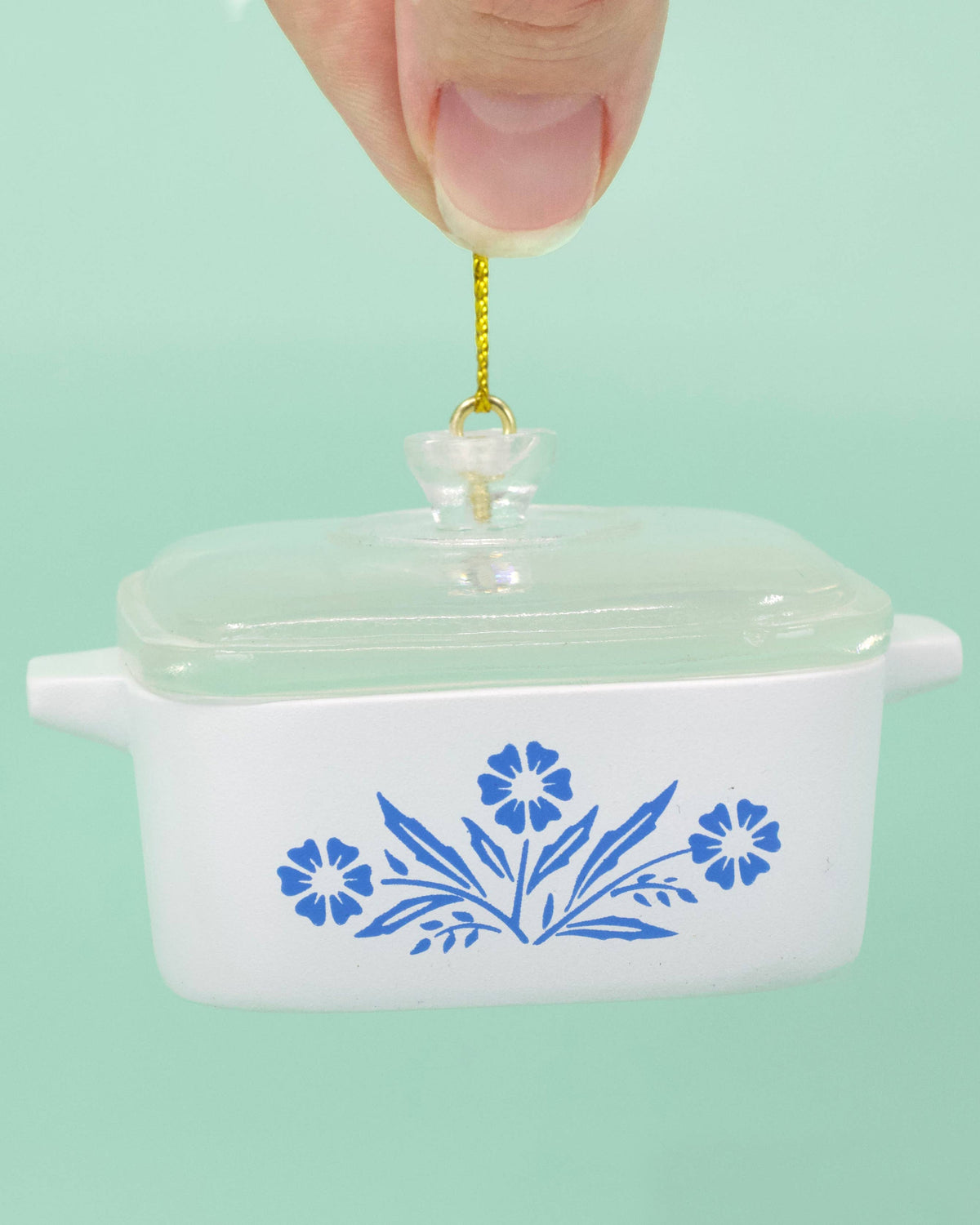 White ceramic ornament with blue floral patterns on a light green background