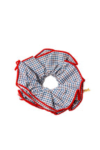 Checkered blue scrunchie with red border on a white background