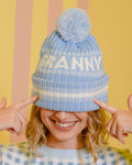 Person wearing a blue beanie with 'GRANNY' text against a striped background
