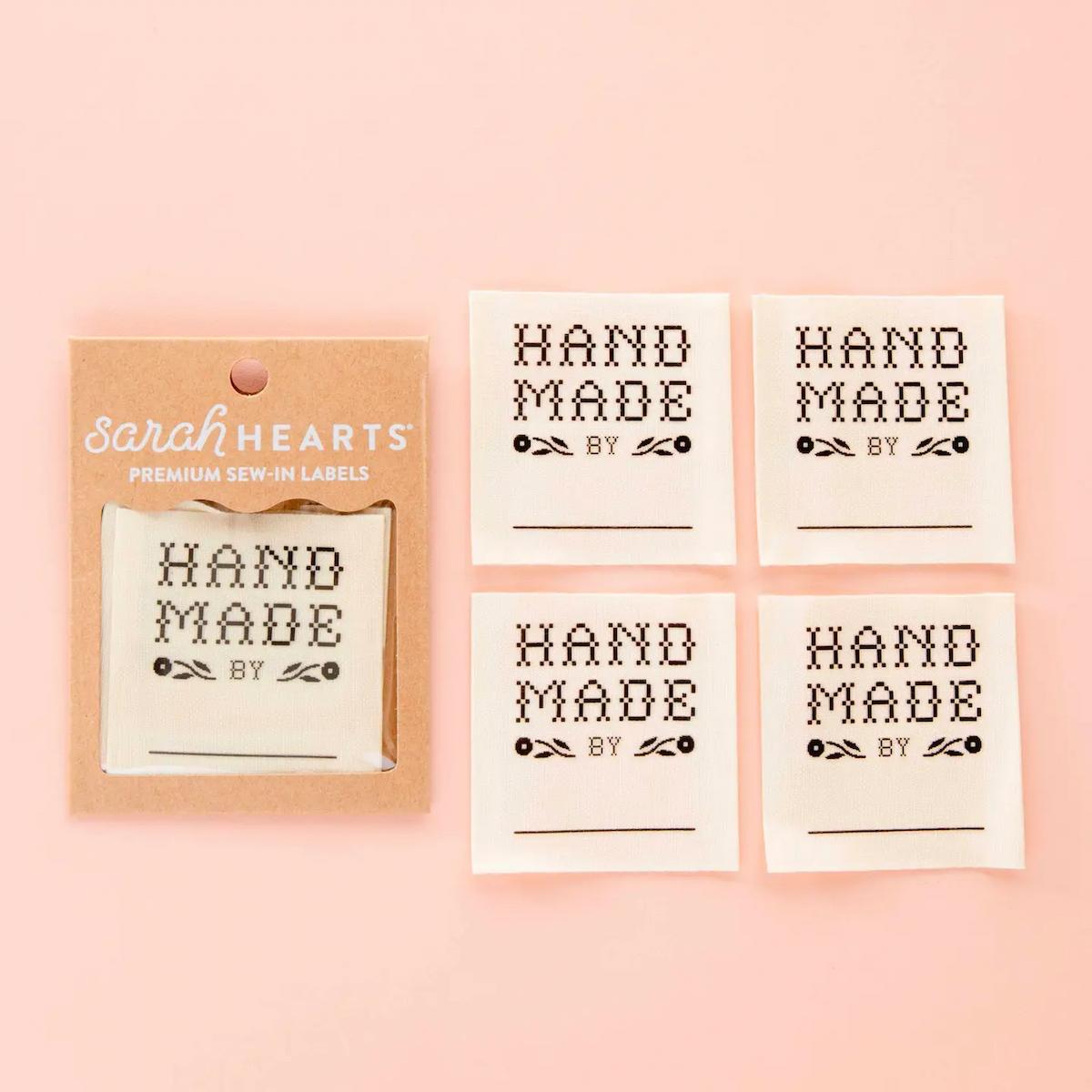 Set of 'Hand Made by' labels with packaging on a pink background