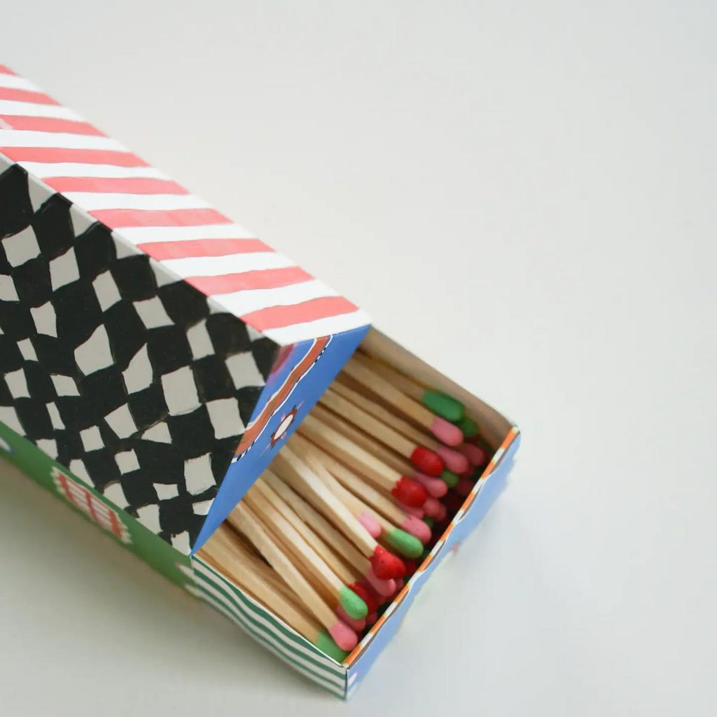 Matches in a colorful box with a geometric pattern on a light gray background