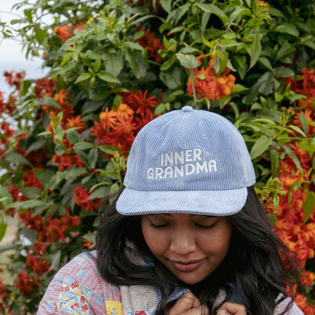 Light Blue corduroy cap with inner grandma written across the cap against a floral background