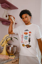 Person wearing a white t-shirt with retro graphic designs in a kitchen setting