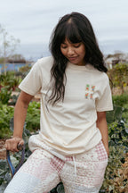 Woman wearing a cream t-shirt with a mahjong tile design outdoors