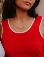 Person wearing a red tank top with lace trim and a gold necklace with 'Grandma' on it.