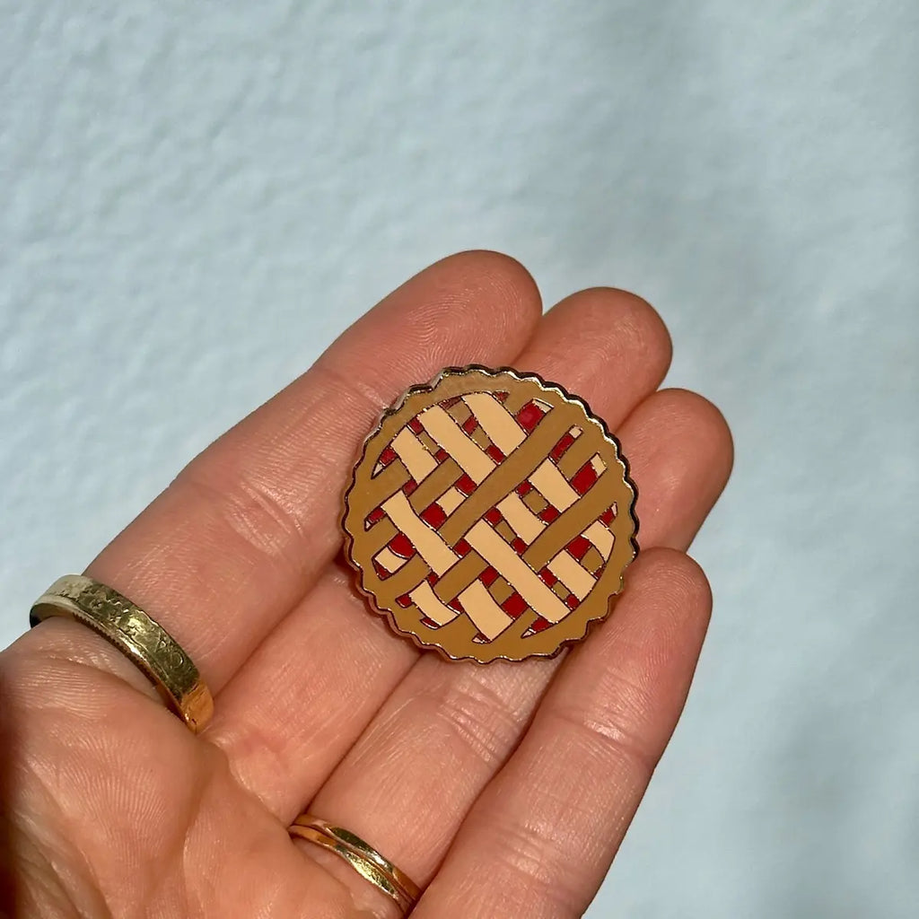 Small pie-shaped decorative item held in a hand against a light blue background