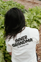 Person wearing a white shirt with 'INNER GRANDMA Est. January 2026' text in a garden setting