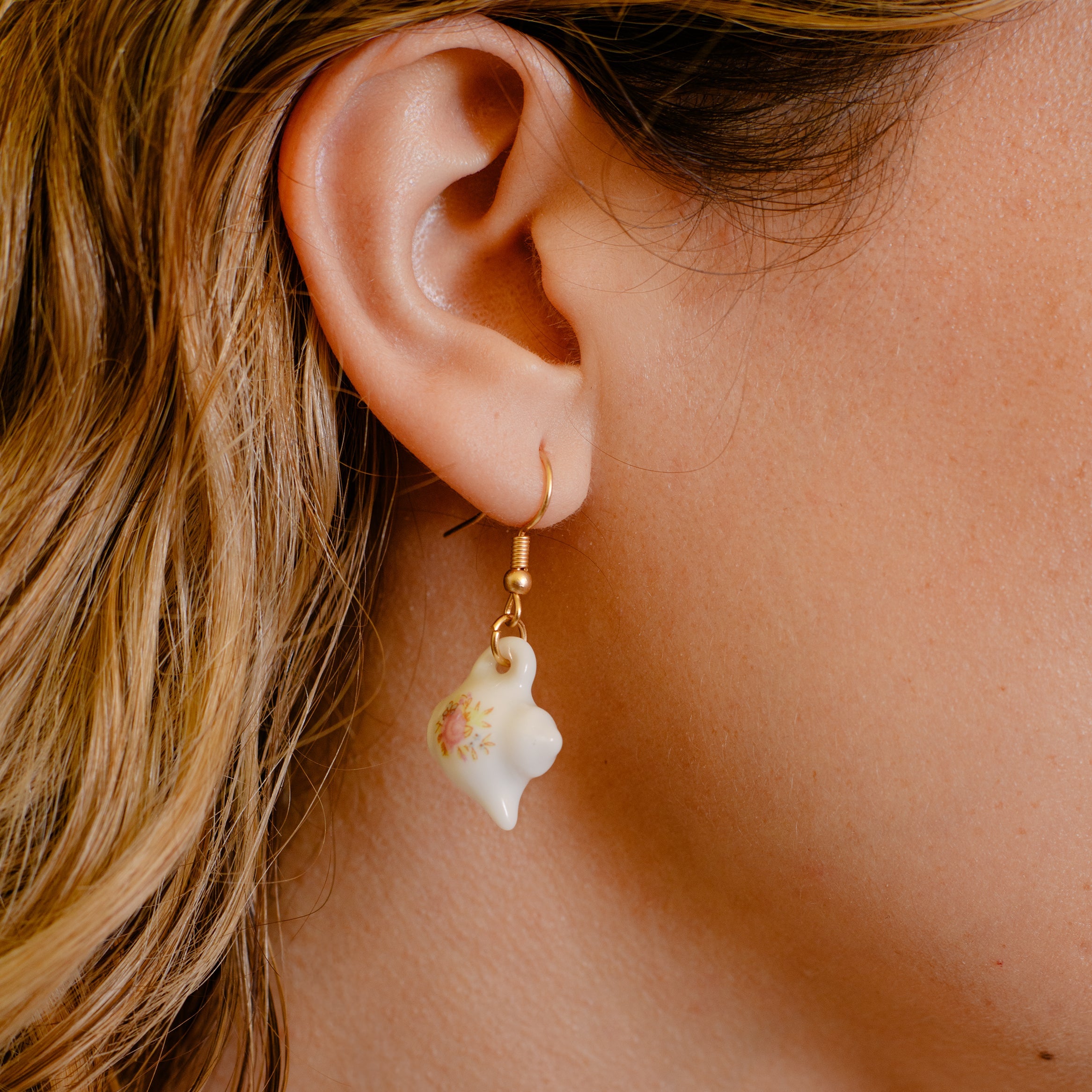 Close-up of a person wearing a teapot with a floral design.