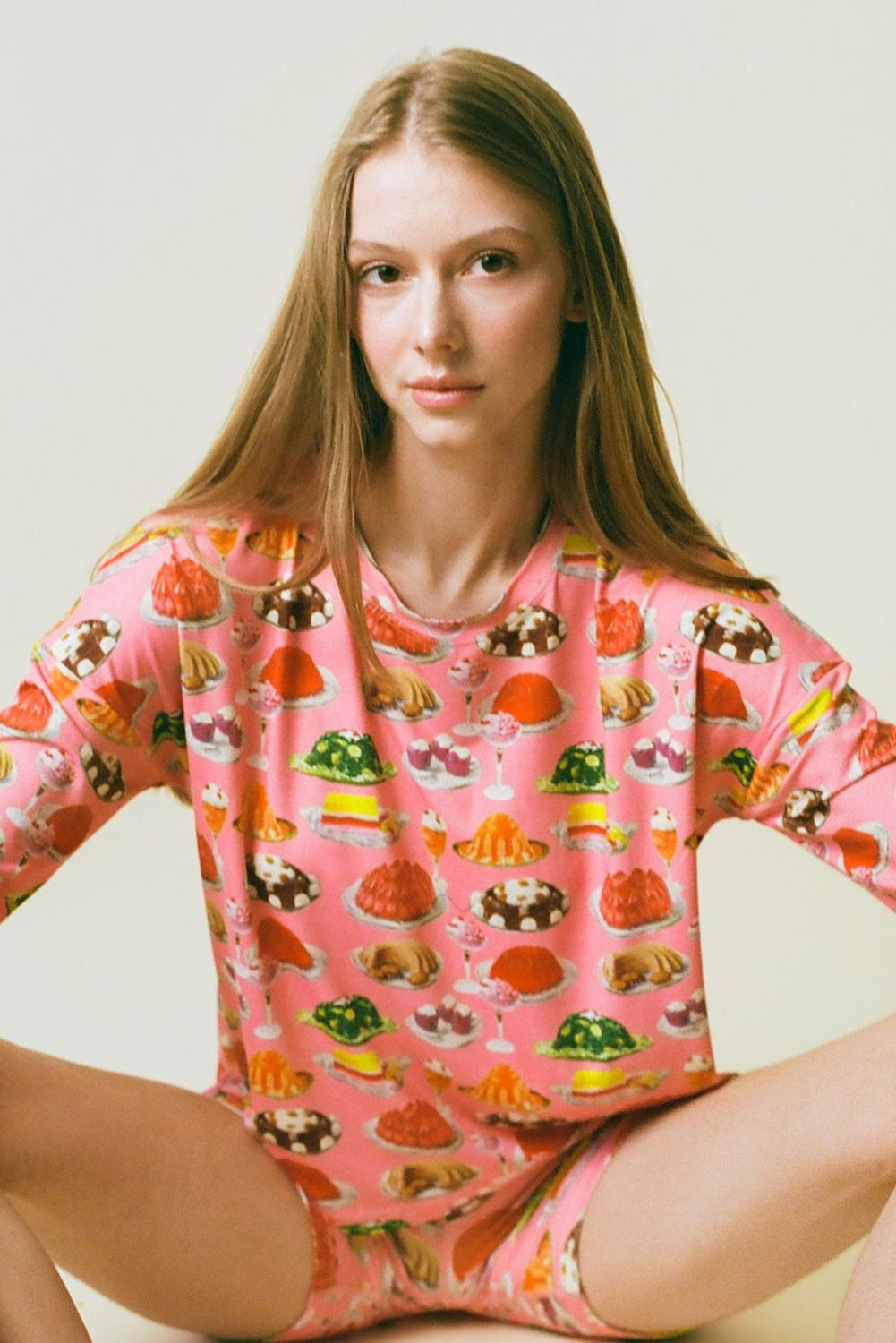 Person wearing a pink gelatin set with food print on a light background