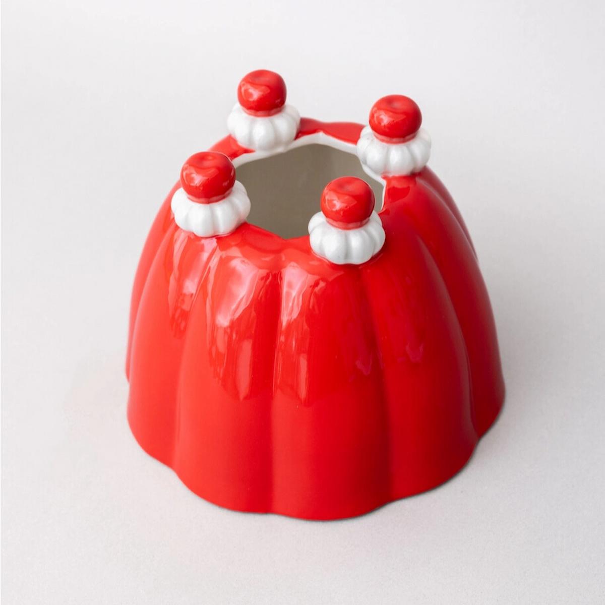 Red jelly mold with white and red decorative elements on a light gray background
