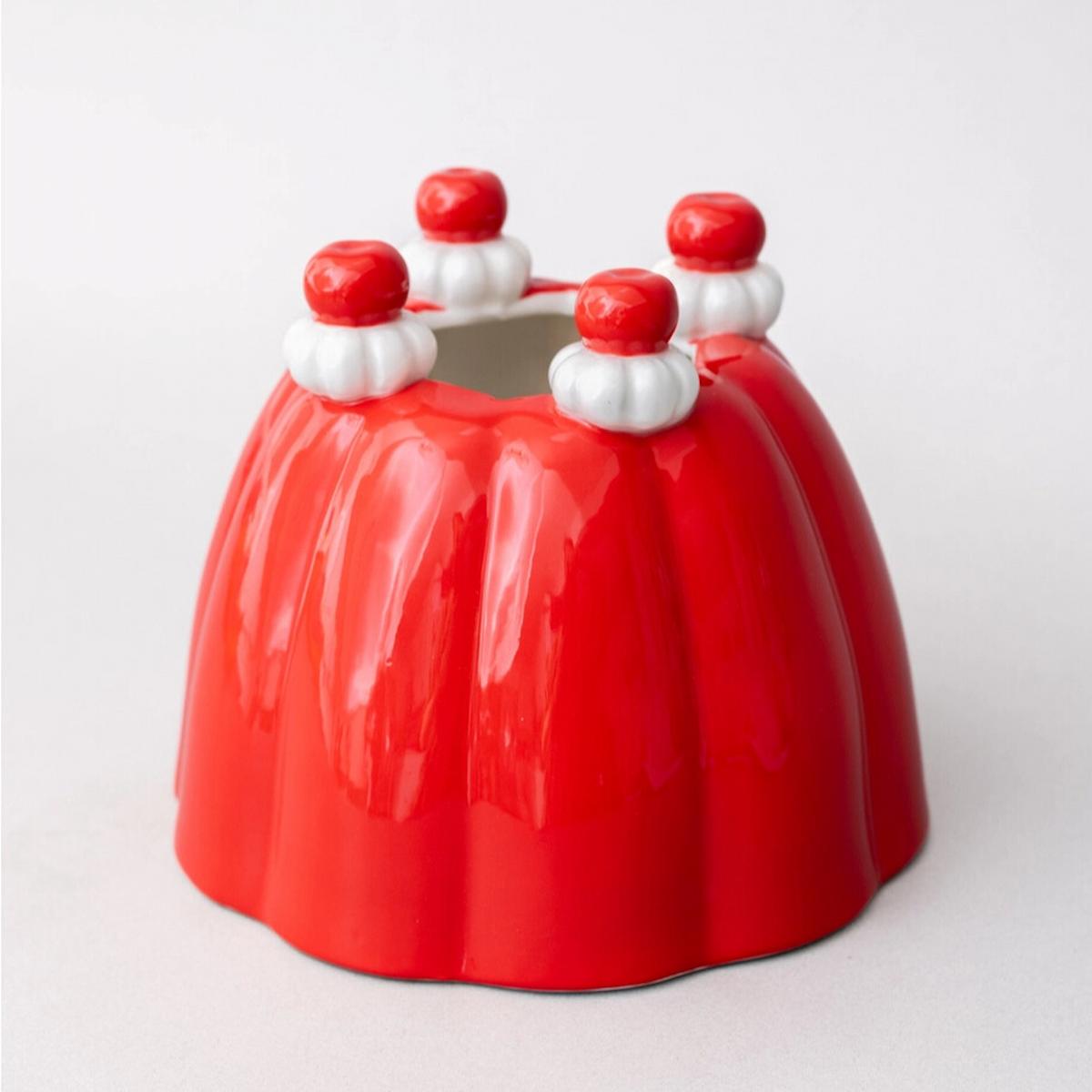 Red ceramic mold with white and red decorative elements on a light gray background