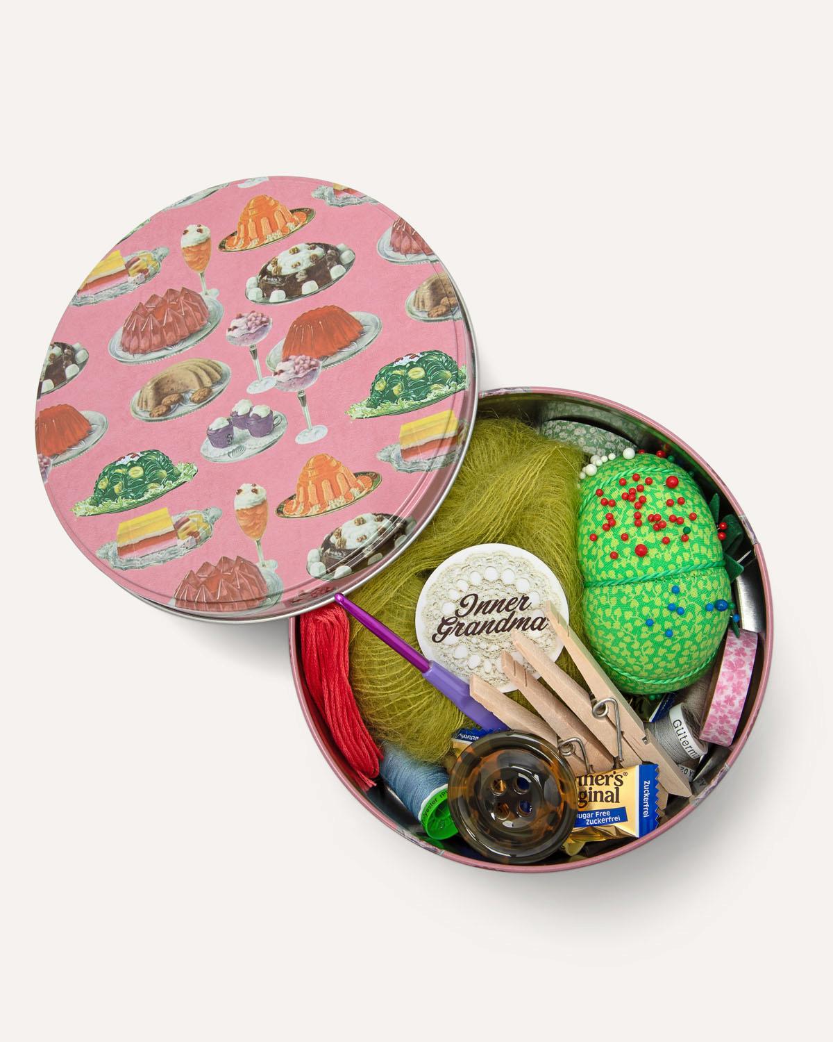 Colorful sewing kit with a pink lid featuring food illustrations on a white background