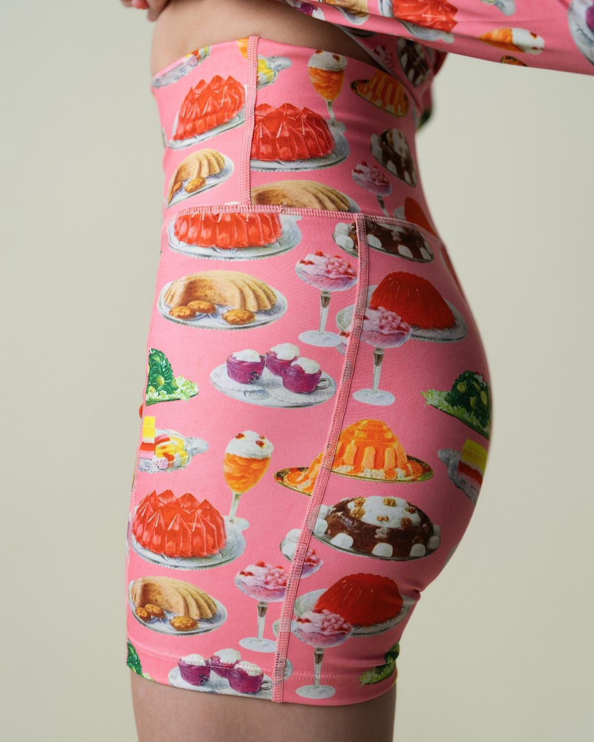 Pink shorts with dessert pattern on a plain background