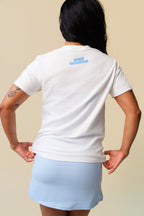 Back of person wearing a white t-shirt with inner grandma printed in blue on a beige background.