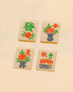 Four wooden tiles with colorful designs and text on a beige background