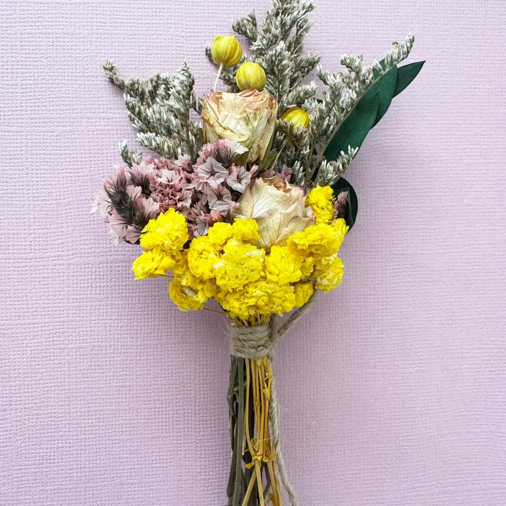 Bouquet of yellow and pink flowers on a light purple background
