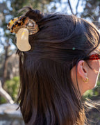 Close-up of a person's hair with decorative hair clips outdoors