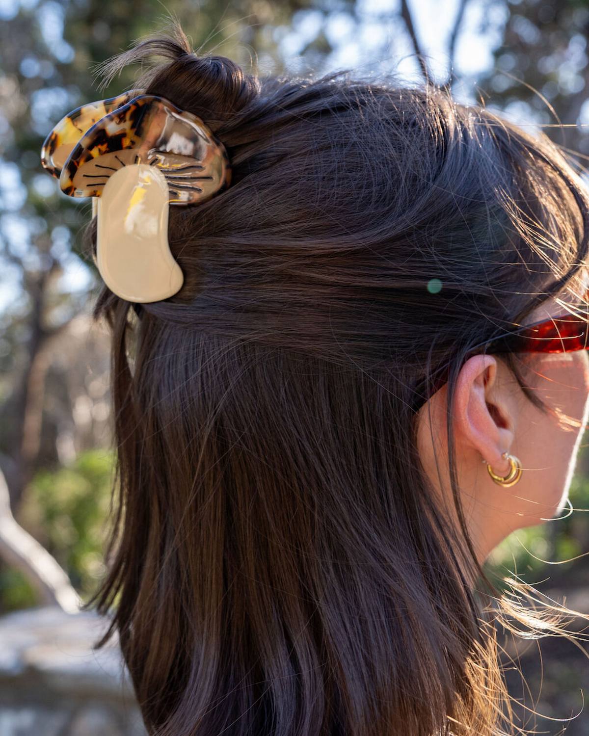 Close-up of a person's hair with decorative hair clips outdoors