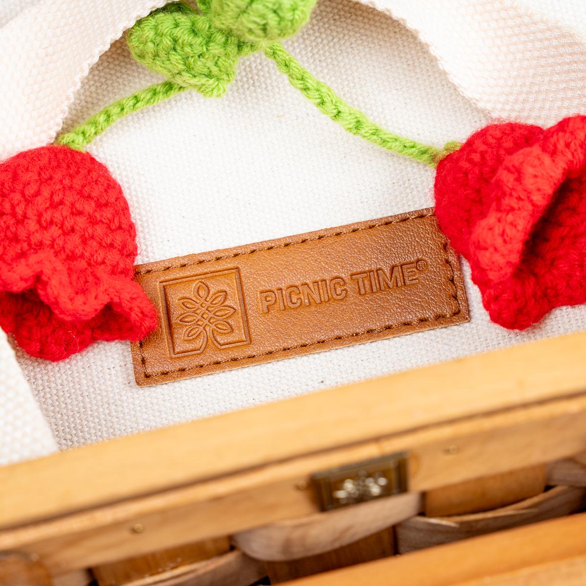 Picnic basket with 'Picnic Time' branding, decorated with red and green crocheted flowers.