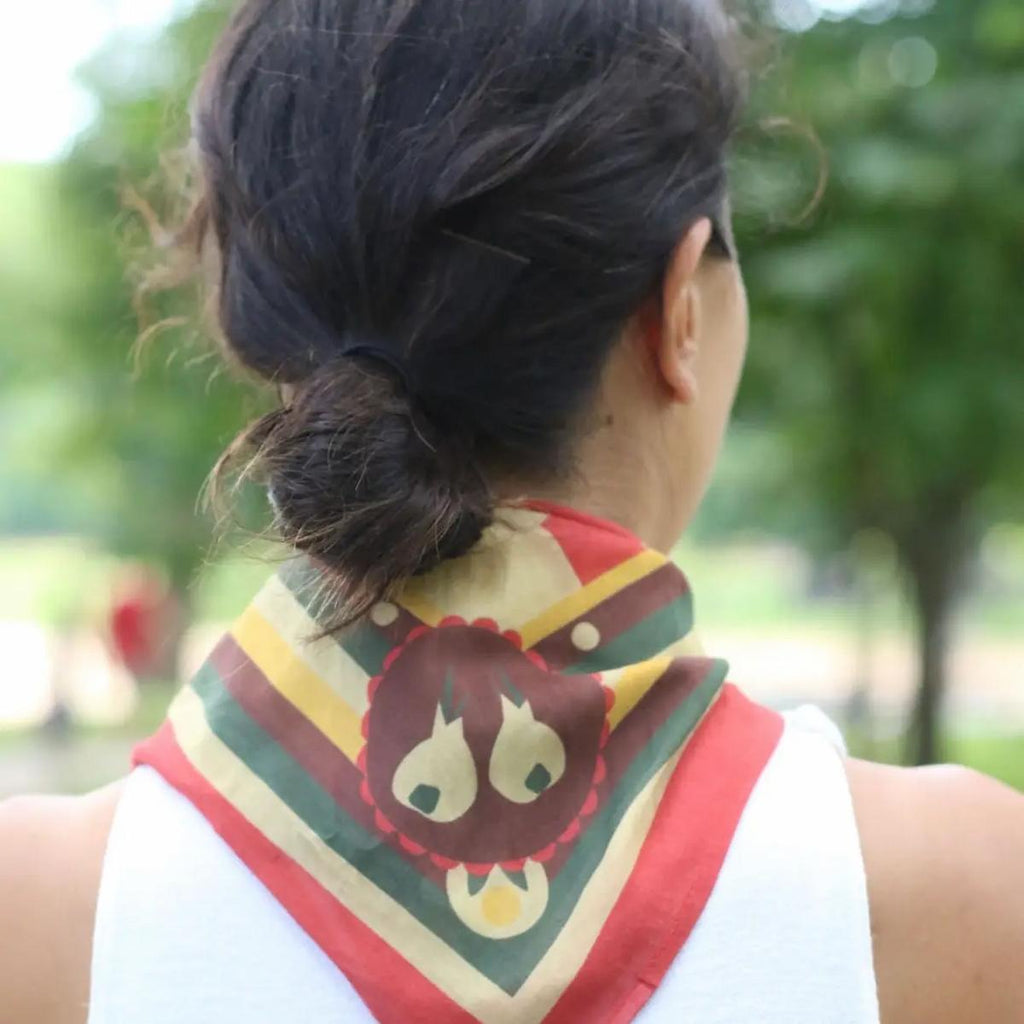 Person wearing a colorful bandana with an owl design outdoors