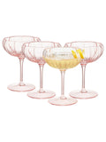 Set of four pink cocktail glasses with a drink inside on a white background