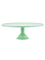 Green cake stand with a clear glass plate on a white background
