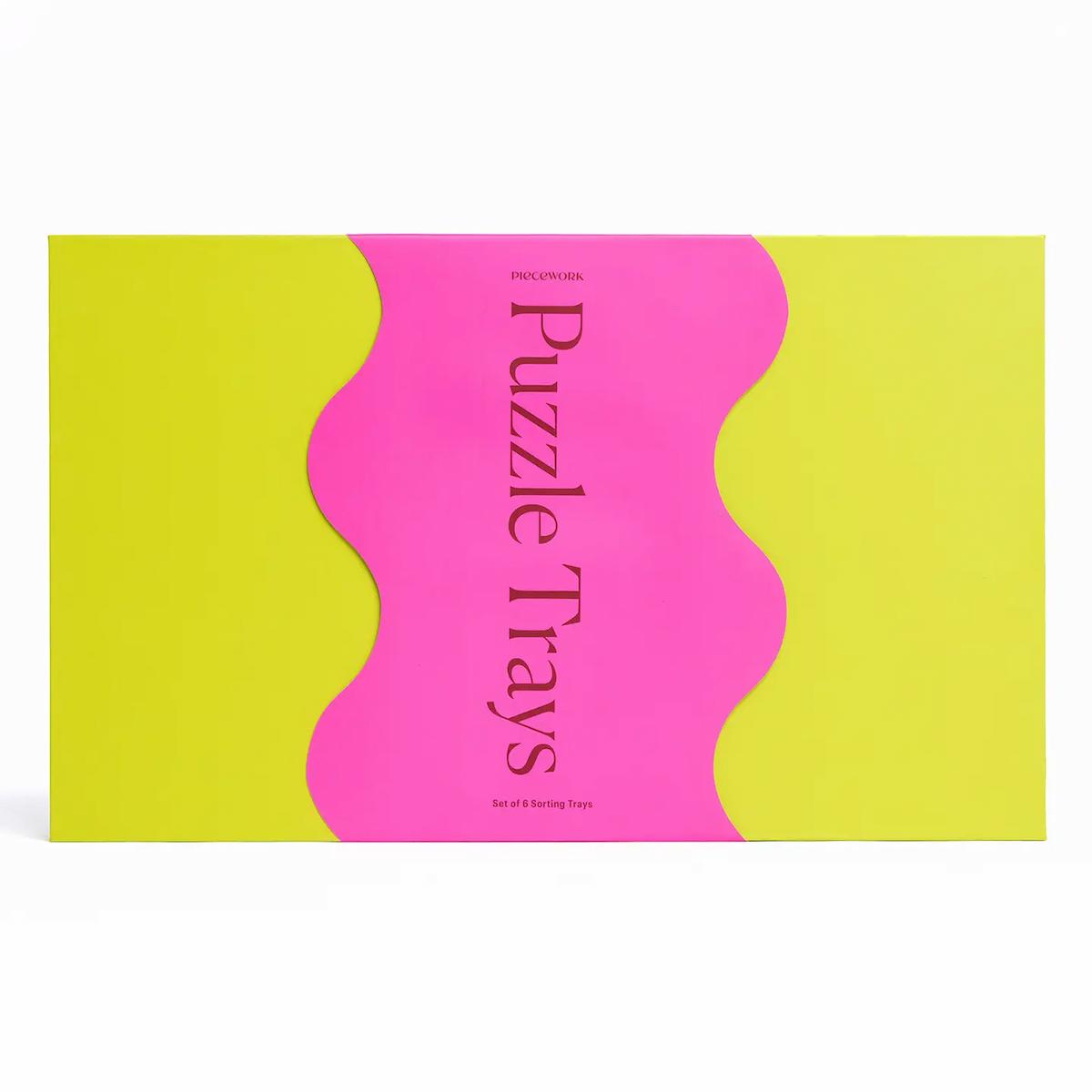 Packaging of Puzzle Trays with pink and green design on a white background