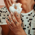 Woman holding a textured donut wearing the crossword puzzle tee 
